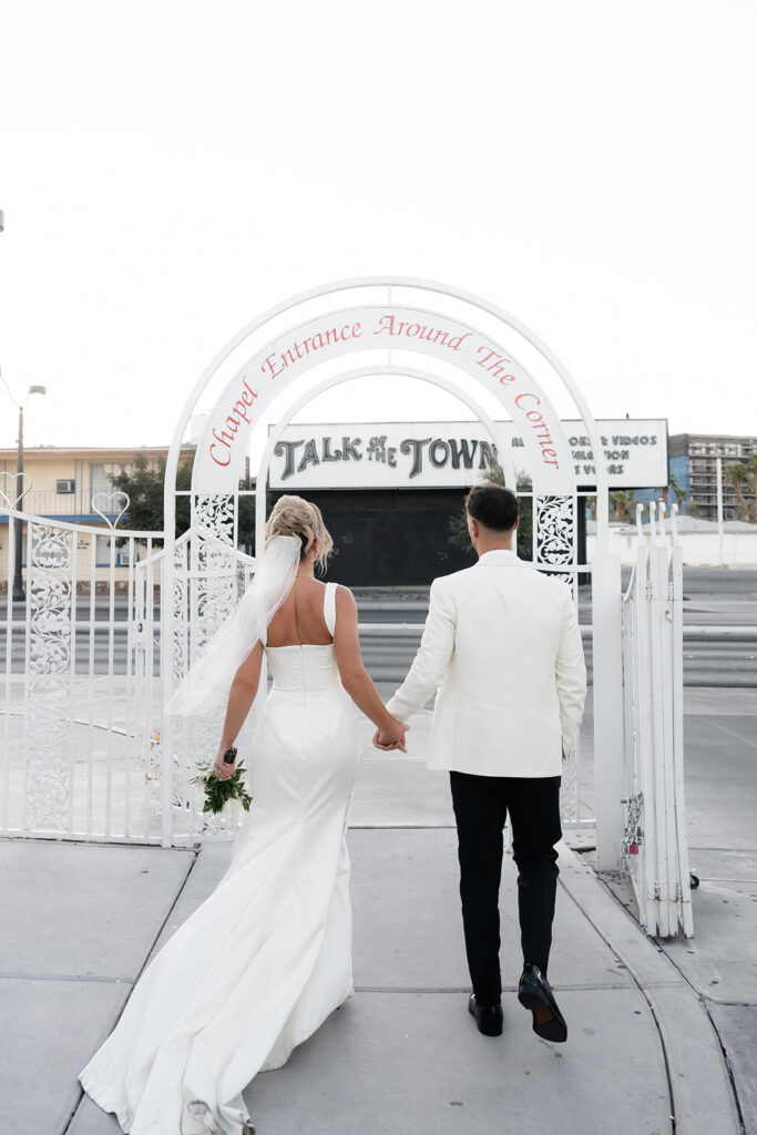 Bride and groom walking outside of a Little White Chapel for their classy elopement in Vegas.