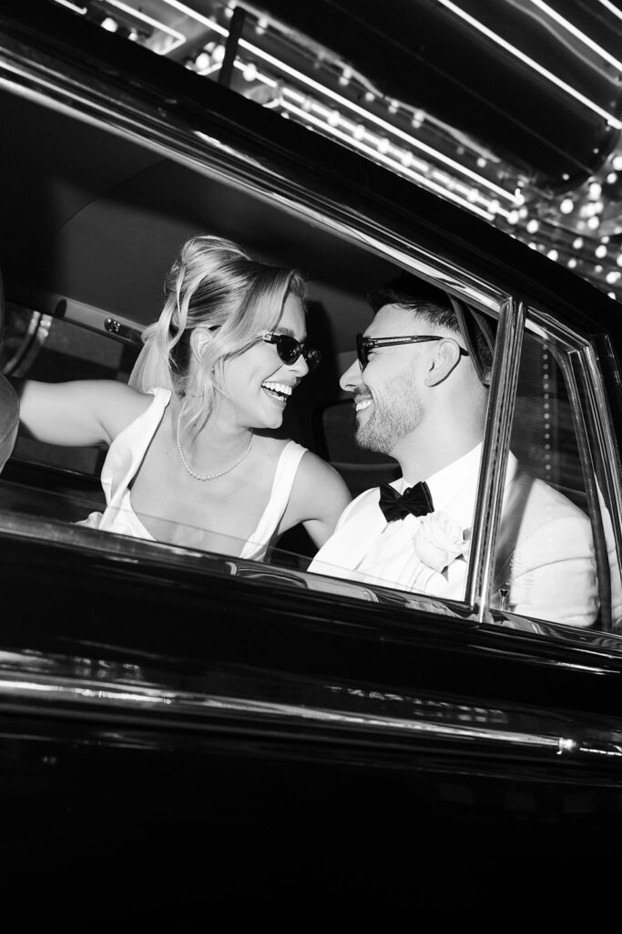 Couple laughing inside a vintage Rolls Royce during their Fremont Street elopement in Las Vegas.