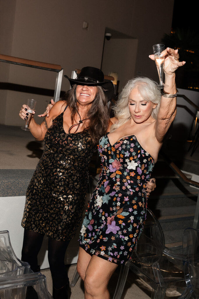 Guests raising a champagne glass in celebration during the Boulevard Pool Deck ceremony at a Cosmopolitan wedding in Las Vegas.