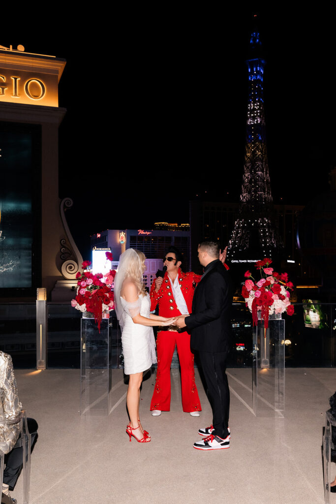 Bride and groom holding hands during their ceremony on the Boulevard Pool Deck at a Cosmopolitan wedding in Las Vegas.