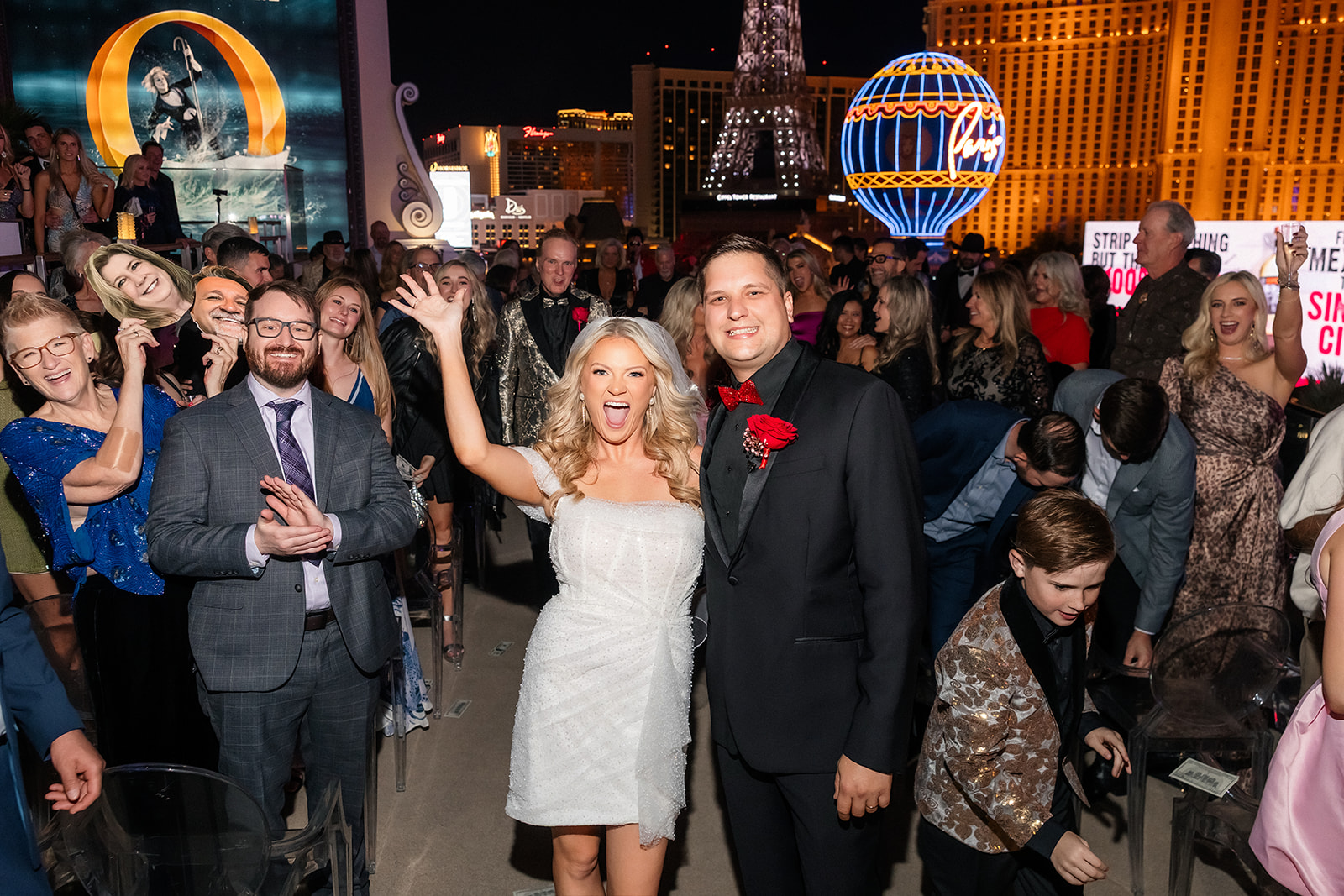 Bride and groom posing for their Las Vegas wedding photos at The Cosmopolitan with all of their guests.