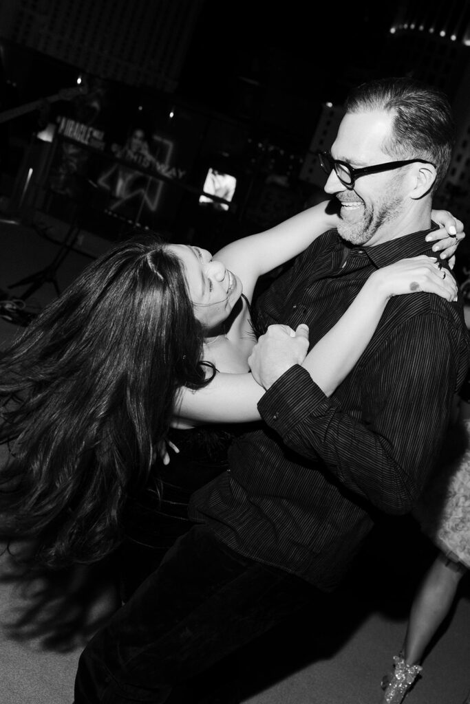Guests laughing and dancing during an evening celebration at a Cosmopolitan wedding reception in Las Vegas.