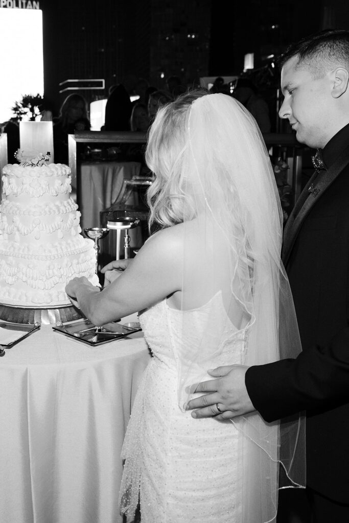 Bride and groom cutting their wedding cake during an evening reception at the Cosmopolitan in Las Vegas.