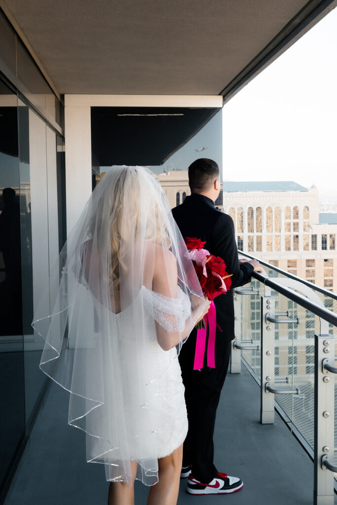 Bride approaches the groom from behind on a balcony at a Cosmopolitan wedding in Las Vegas before their first look.