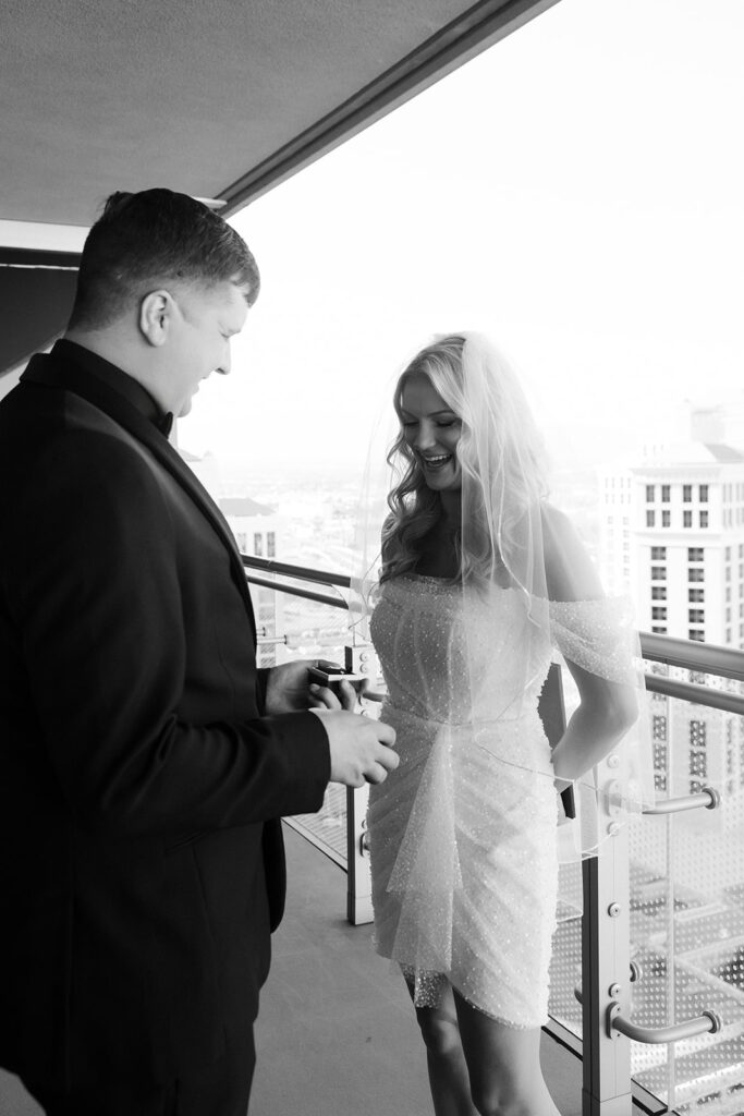Black and white image of the couple smiling at each other during their first look on a Cosmopolitan balcony in Las Vegas.