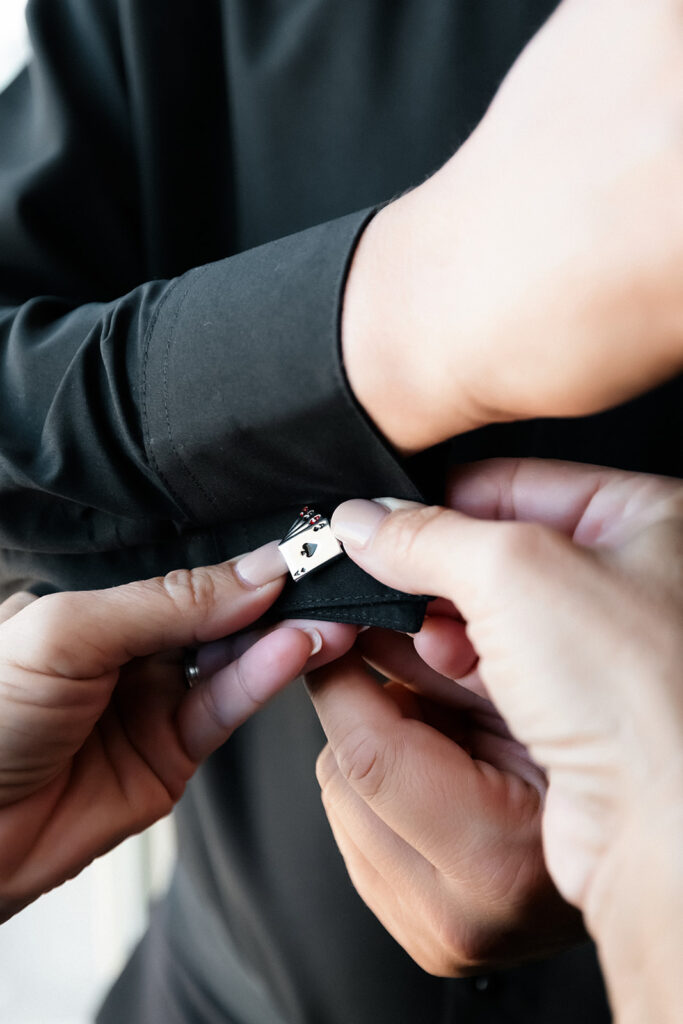 Close-up photo of cufflinks being fastened on the groom’s sleeve during getting ready at a Cosmopolitan wedding in Las Vegas.