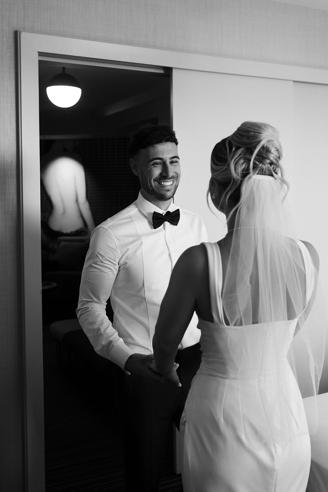 Black and white photo of a groom seeing his bride for the first time during their first look at The Cosmopolitan. 