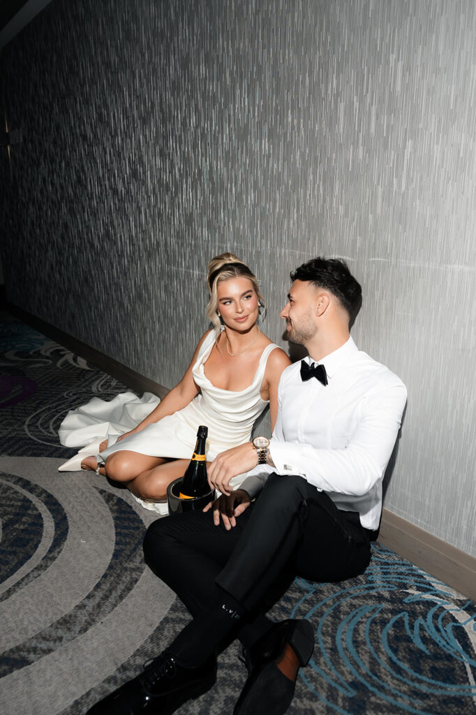 Flash photo of a bride and groom sitting in the hallway at The Cosmopolitan for their classy elopement in Las Vegas. 
