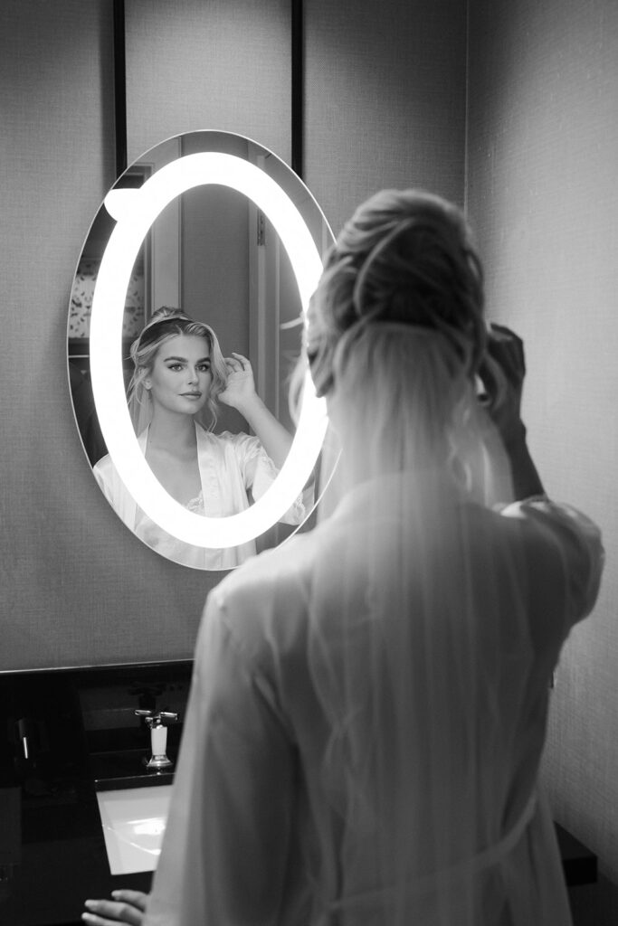 Black and white photo of a bride posing in the mirror at The Cosmopolitan in Las Vegas.