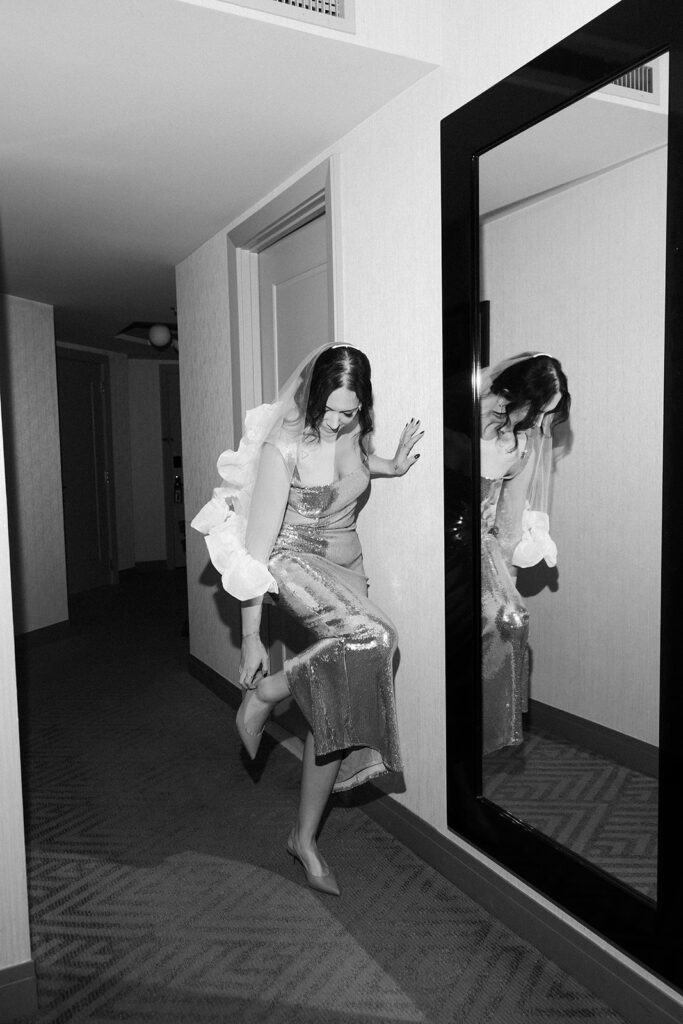 Bride adjusting heels in a sequined dress while getting ready at The Cosmopolitan Las Vegas.