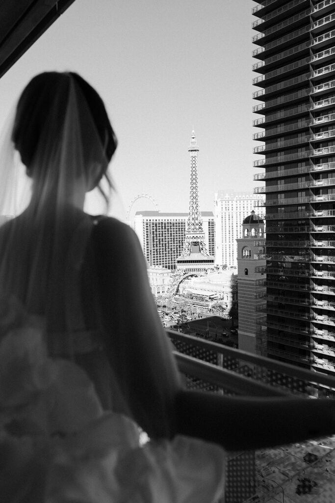 Bride standing on the wraparound terrace at The Cosmopolitan with Las Vegas Strip views.