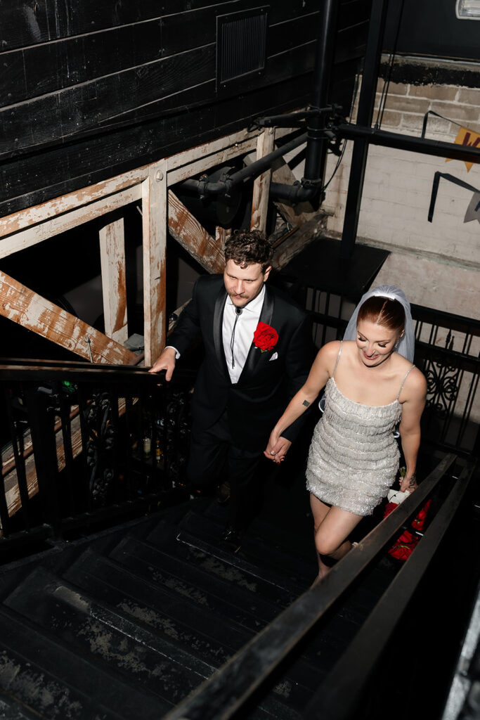 Couple walking up the stairs inside Commonwealth during their Las Vegas wedding reception.