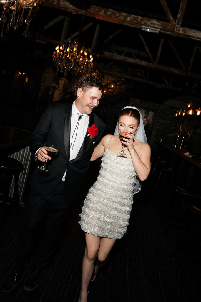 Bride and groom walking together inside Commonwealth with cocktails during their Las Vegas wedding reception.