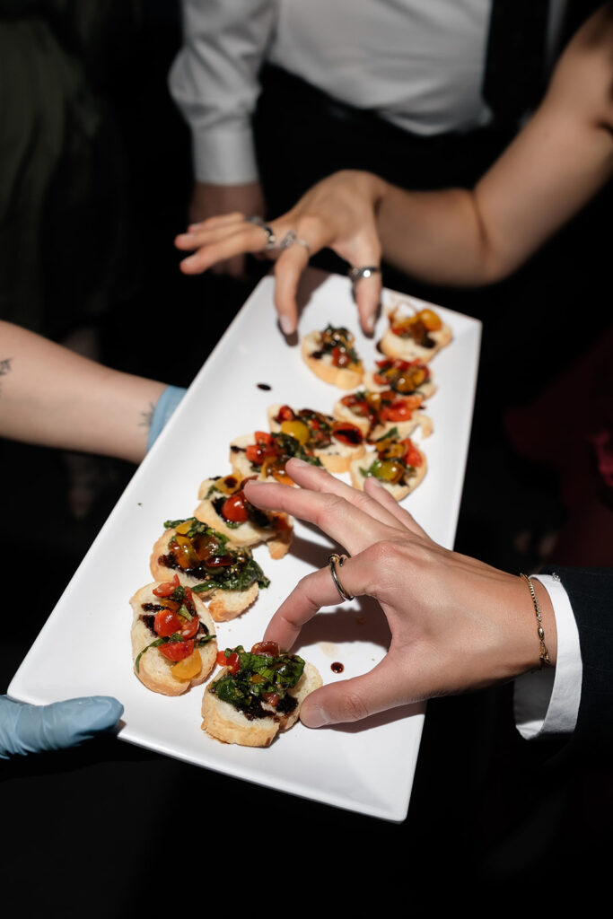 Guests reaching for passed appetizers during a Commonwealth Las Vegas wedding reception.