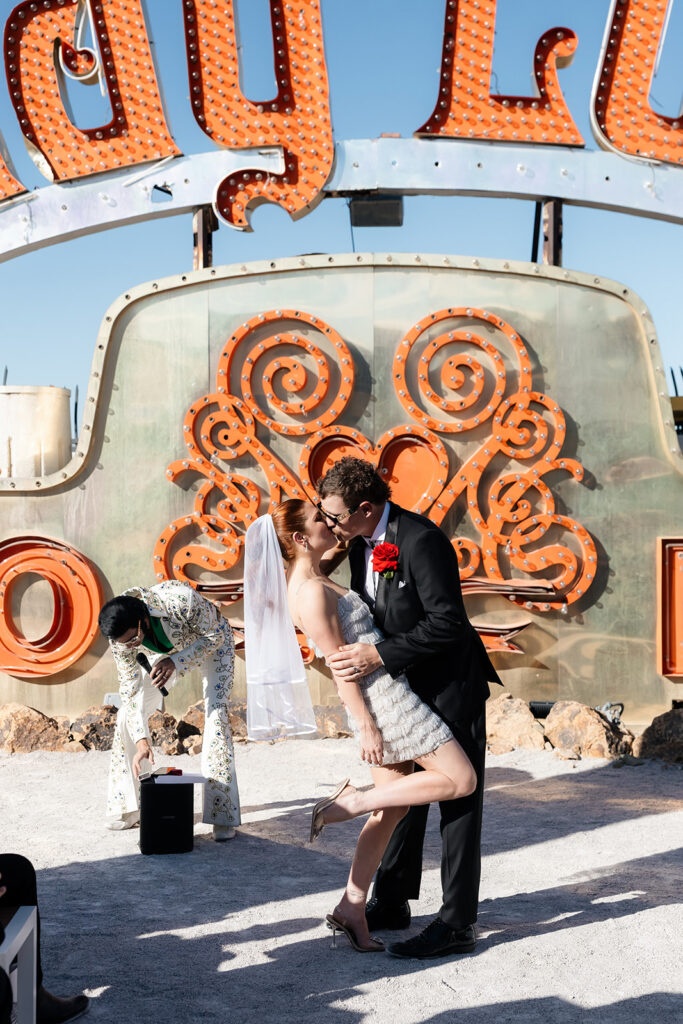 Bride and groom sharing a kiss during their Neon Museum wedding ceremony in Las Vegas.