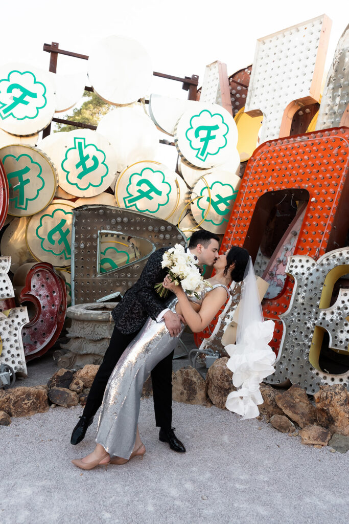 Bride and groom kissing in front of the neon signs at the Neon Museum in Las Vegas.