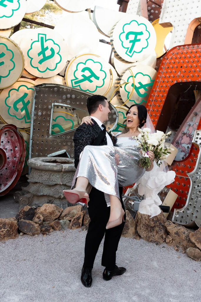 Groom lifting his bride during their Neon Museum wedding photos.