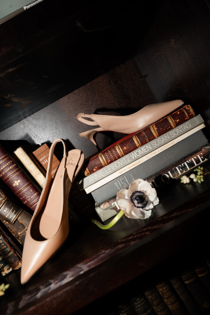 Bride’s heels styled with books and florals inside the NoMad Library for a Las Vegas micro wedding.