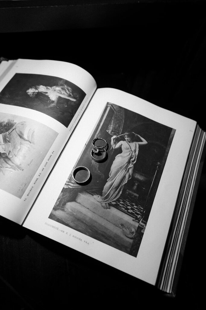 Wedding rings photographed on an open book inside the NoMad Library during a Las Vegas micro wedding reception.