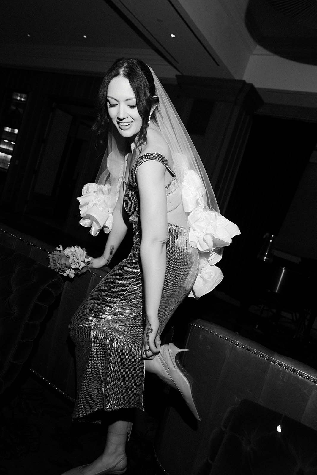 Bride adjusting her heels inside the NoMad Library during an intimate Las Vegas micro wedding reception.