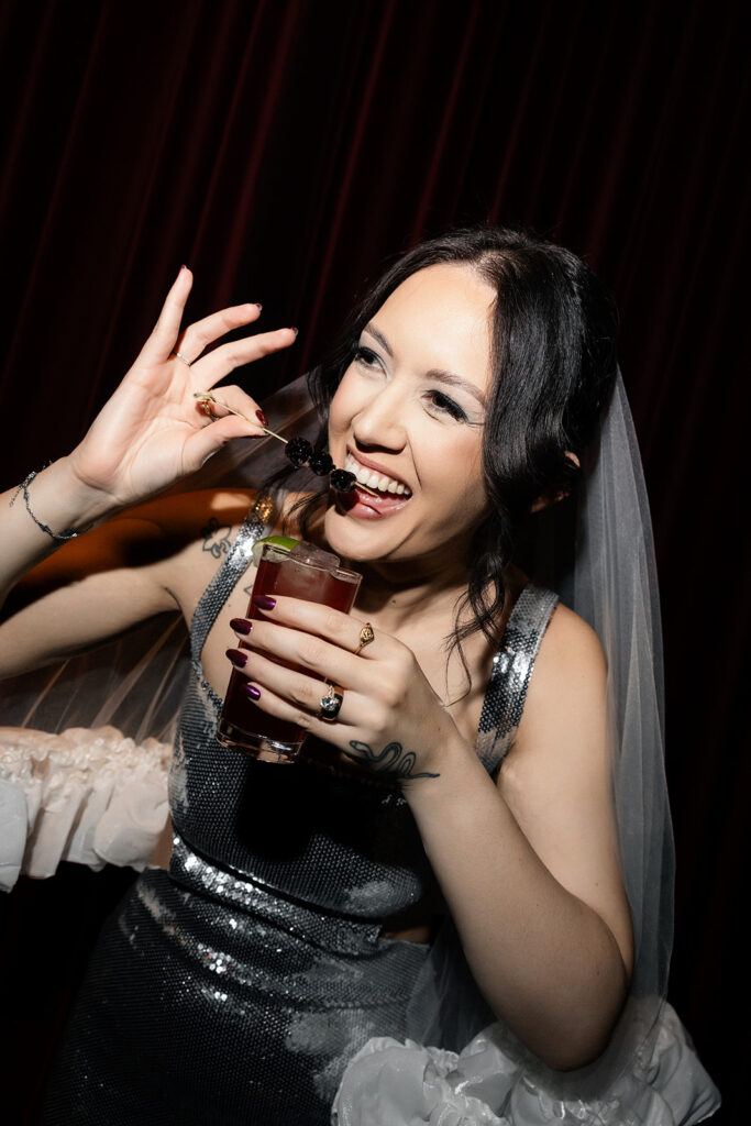 Bride laughing while enjoying a cocktail during her NoMad Library Las Vegas micro wedding reception.
