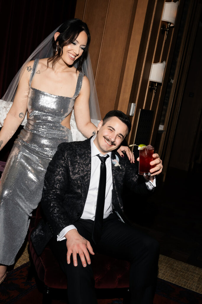 Couple sharing drinks and laughing during their NoMad Library micro wedding reception at Park MGM.