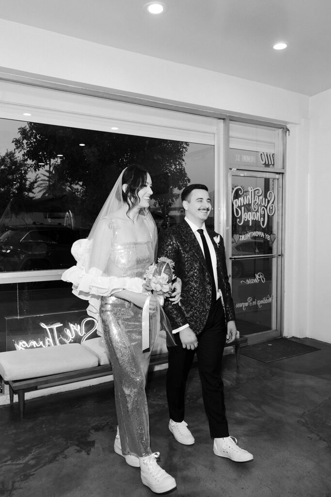 Black and white photo of a bride and groom walking down the aisle together for their Las Vegas micro wedding ceremony at Sure Thing Chapel.