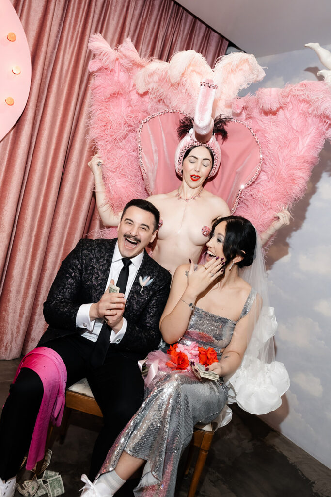 Surely the Showgirl posing behind a newly married couple during a fun Las Vegas micro wedding at Sure Thing Chapel.