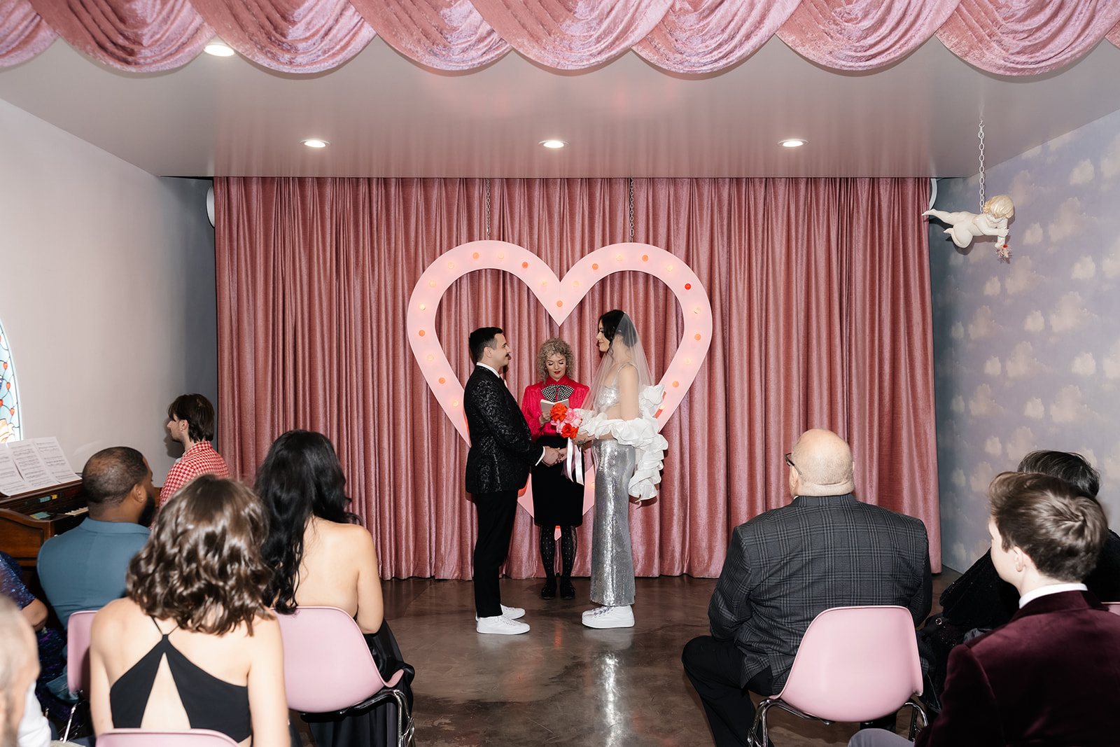 Wide shot of a couple holding hands during their Las Vegas micro wedding ceremony at Sure Thing Chapel.