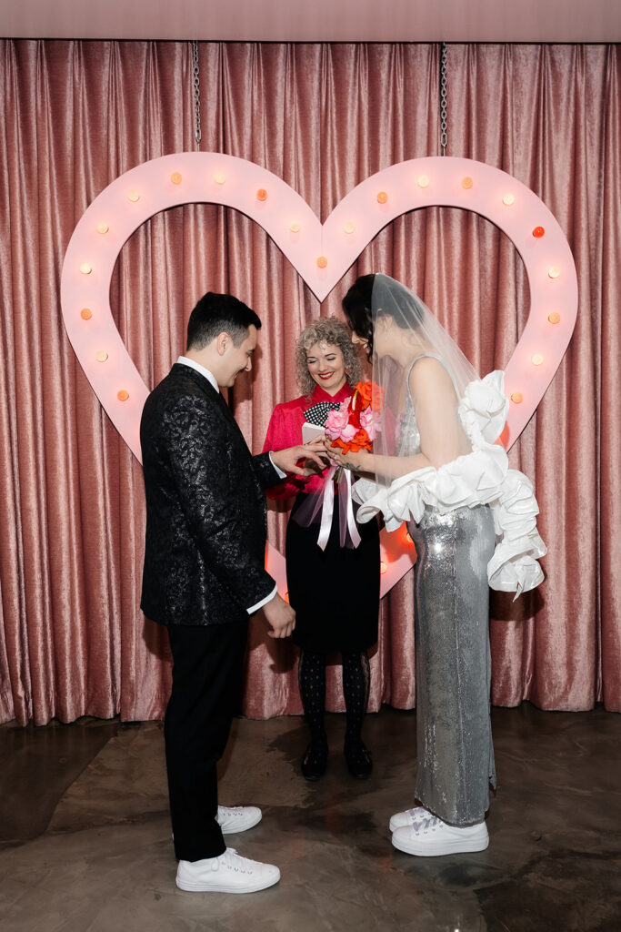 Bride and groom exchanging rings during their Las Vegas micro wedding ceremony at Sure Thing Chapel.