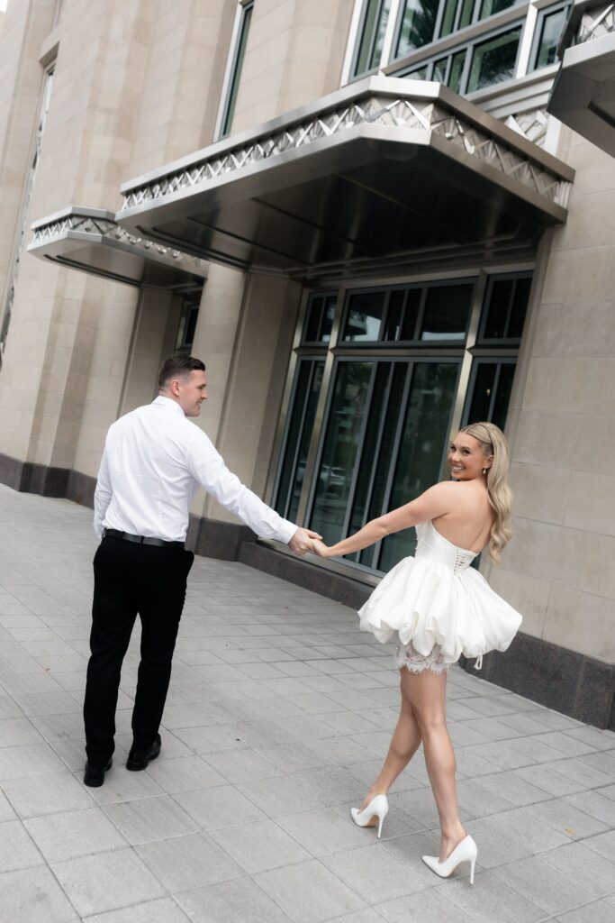 Couple walking hand in hand outside of The Smith's Center for their Las Vegas engagement photos. 