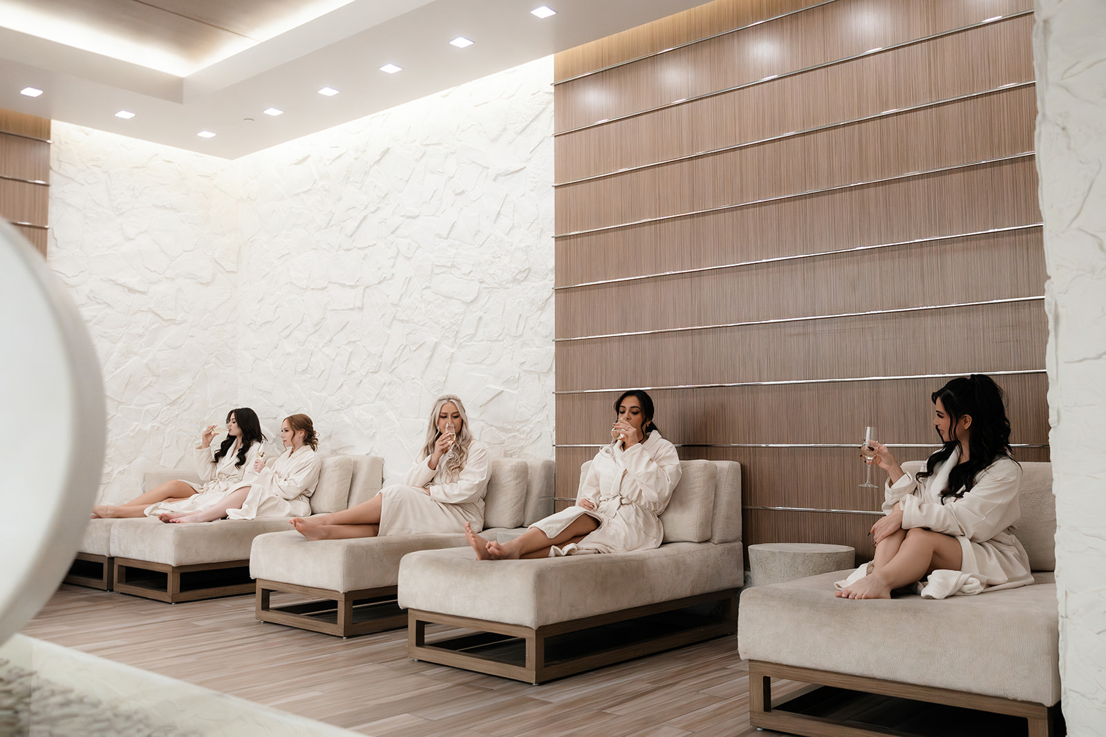 Bride-to-be and friends drinking champagne and lounging during a spa Las Vegas bachelorette party.
