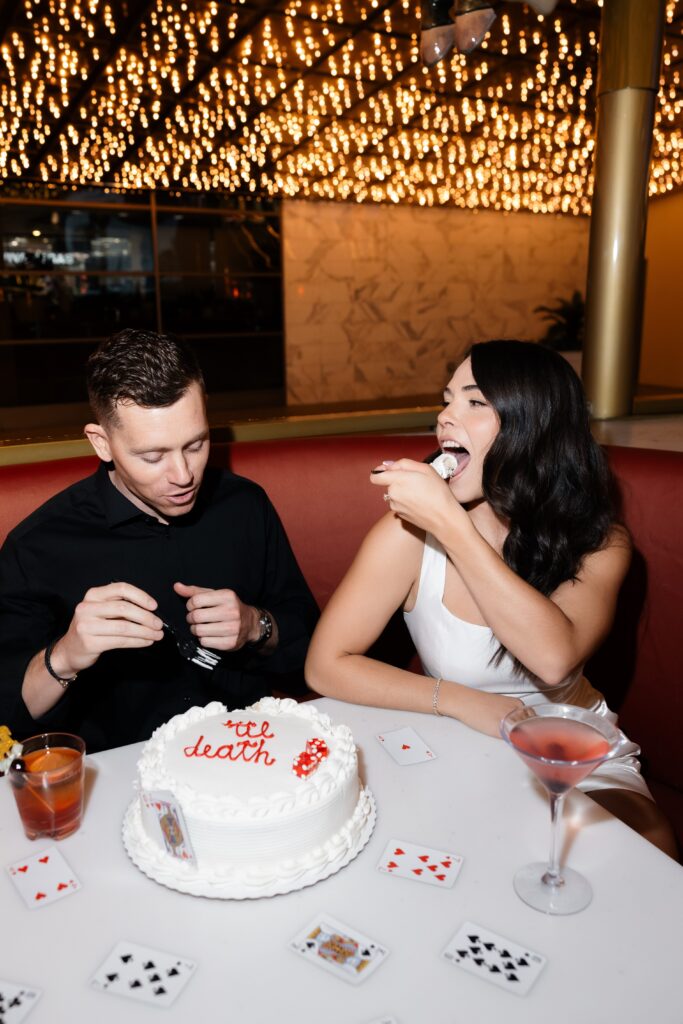 Couple eating cake at Carousel Bar in Las Vegas during their engagement session.