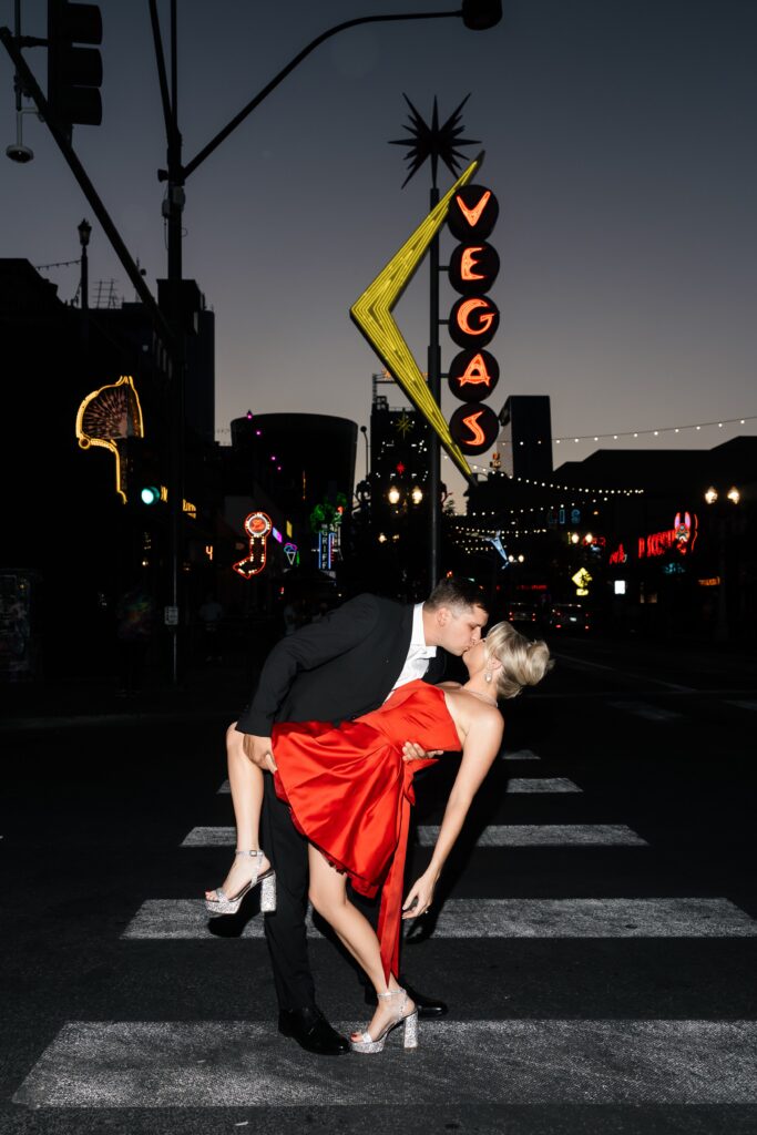 Couple kissing in front of the Vegas sign. 