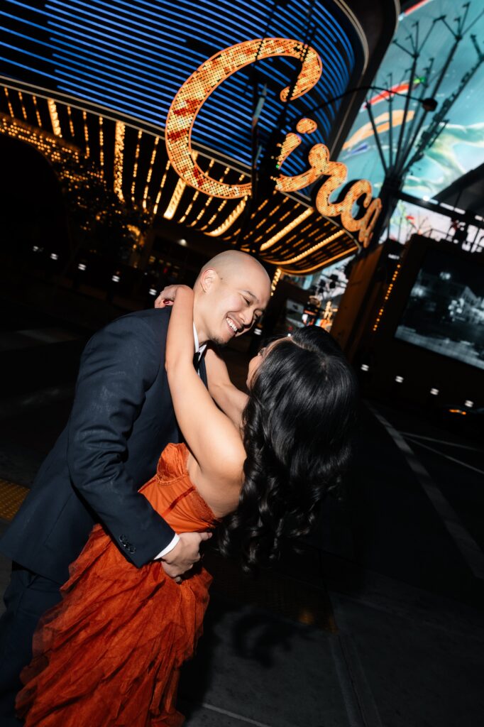 Couple posing in front of Circa for their Las Vegas engagement photos on Fremont Street. 