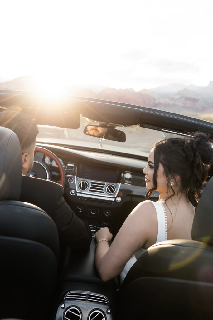 Couple driving in a car in the desert for their Las Vegas engagement photos. 