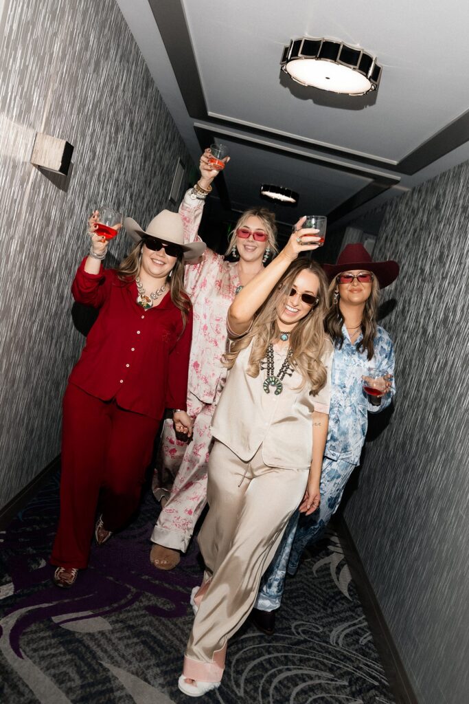 Bride and her friends walking down a hotel hallway. 