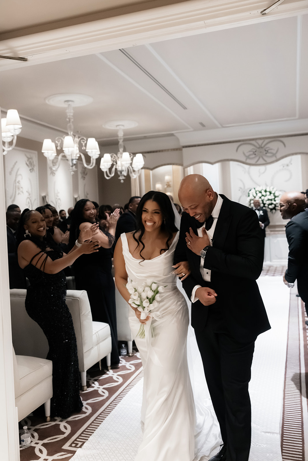 Bride and groom smiling while walking back down the aisle after their Wynn Las Vegas wedding ceremony in the Lavender Salon.