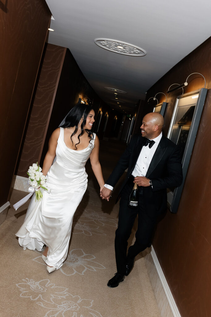 Bride and groom laughing and running down the hallway for their Wynn Las Vegas wedding photos. 