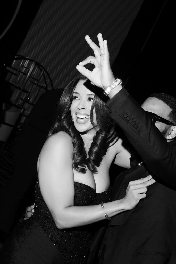 Black and white photo of guests smiling and dancing. 