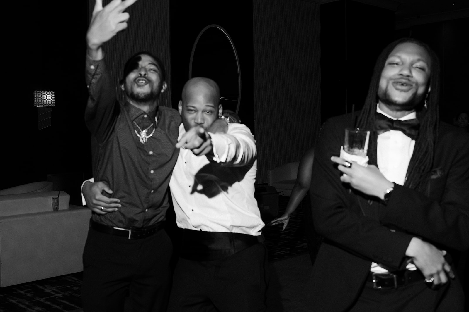 Black and white photo of the groom dancing with friends. 