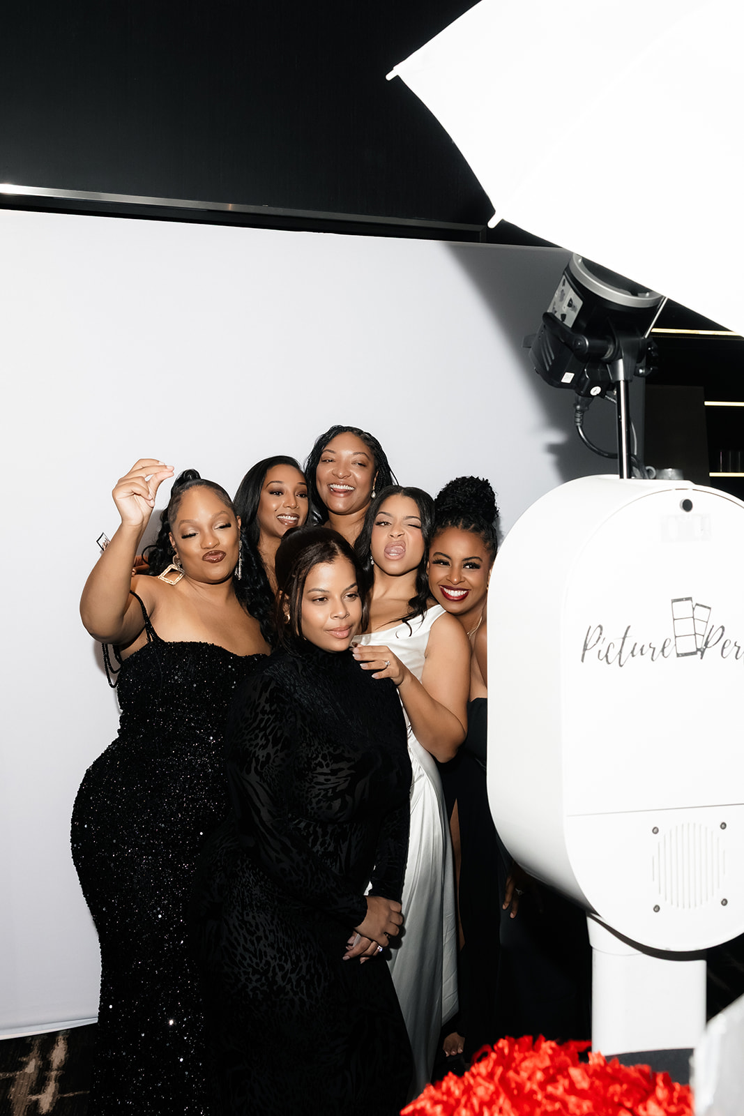 Bride and friends taking photos in a photo booth