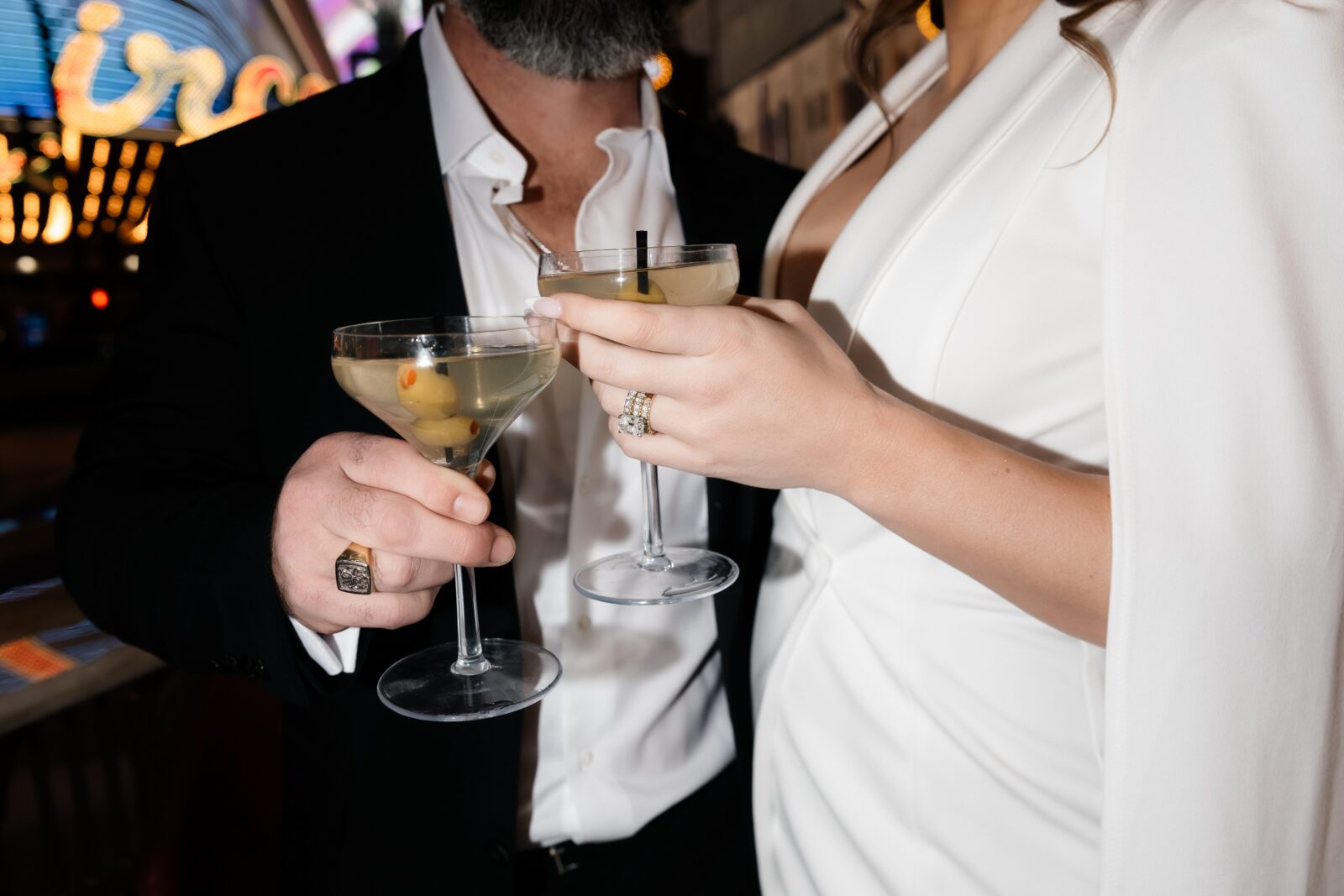Close up shot of a bride and groom holding martinis at Carousel Bar in Las Vegas. 