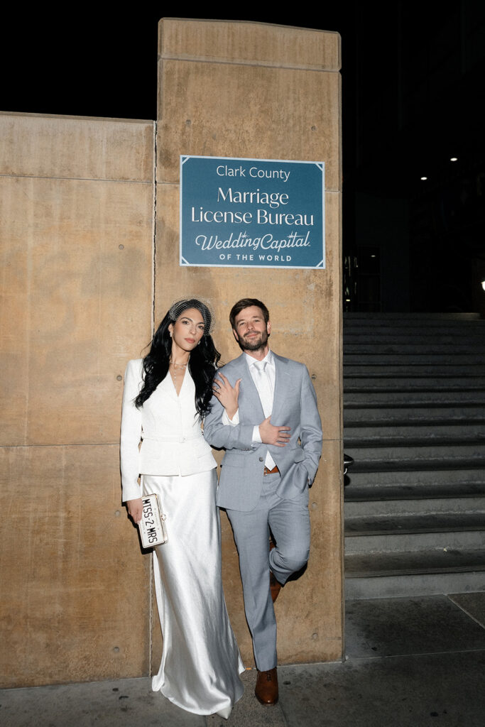 Bride and groom posing outside of the Clark County Marriage License Bureau.