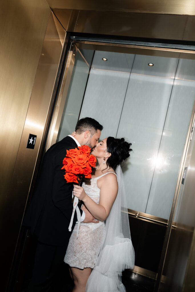 Bride and groom kissing in their hotel during their luxury elopement photos. 