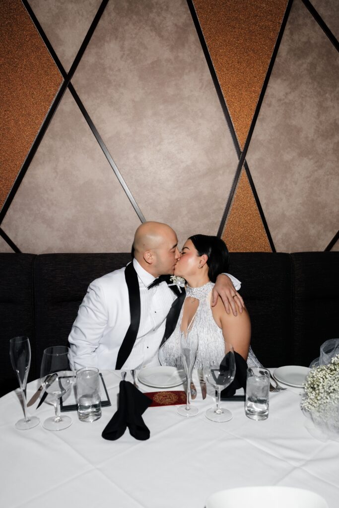 Bride and groom kissing during their intimate elopement dinner.