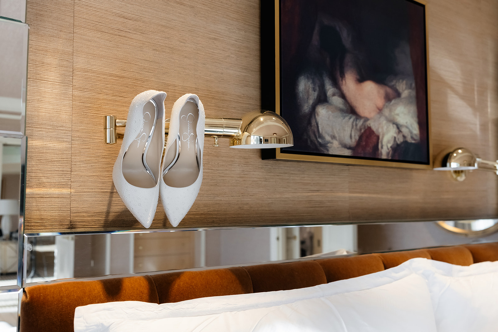 Bride’s white wedding heels displayed on a hotel wall inside a Wynn Las Vegas suite before a luxury elopement.