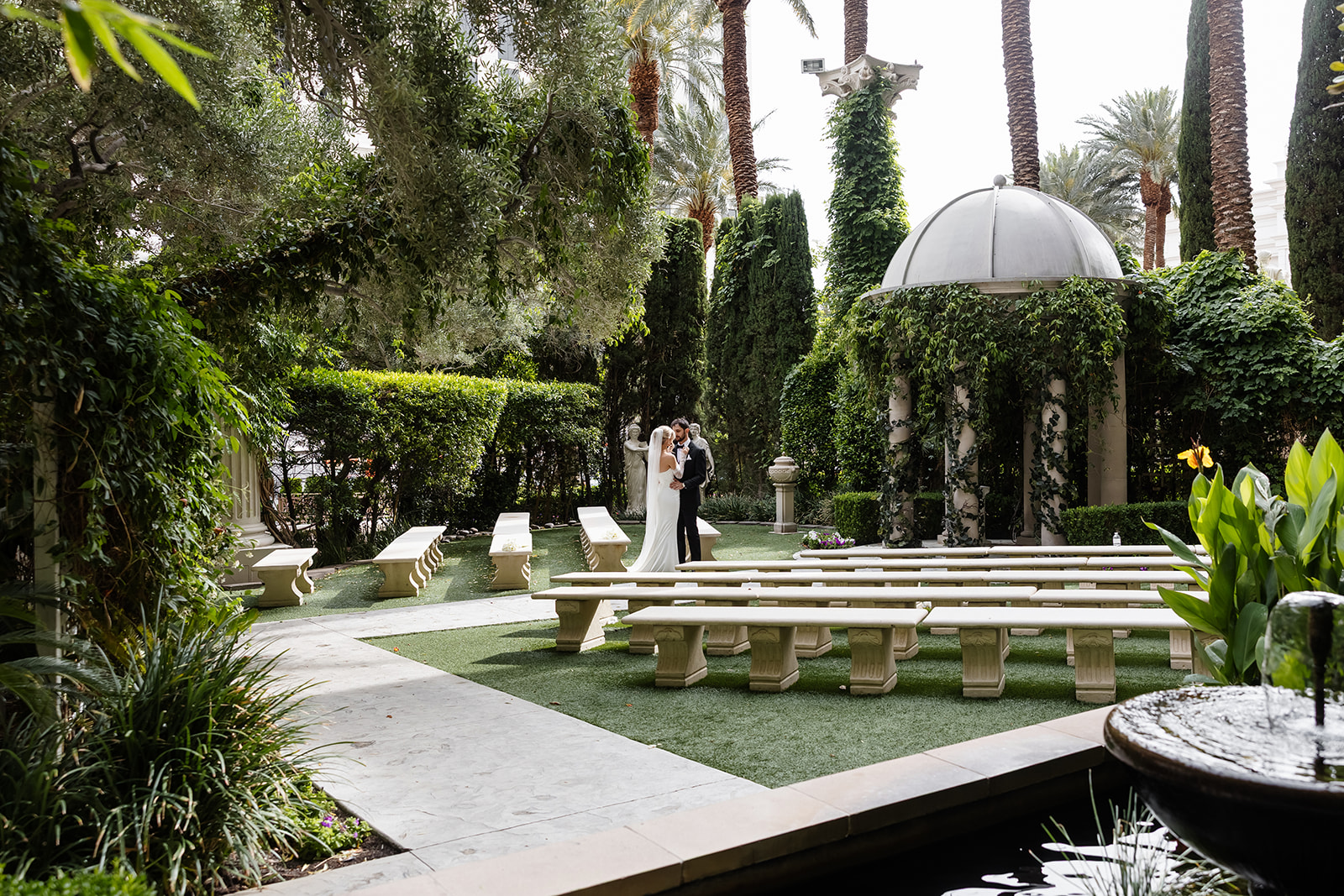 Bride and groom posing at the Caesars Palace garden after their wedding ceremony.