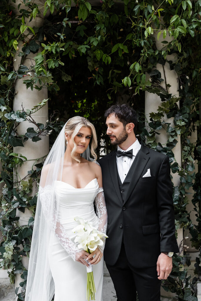 Bride and groom standing together beneath the ivy gazebo after their Venus Garden Chapel at Caesars Palace wedding ceremony.