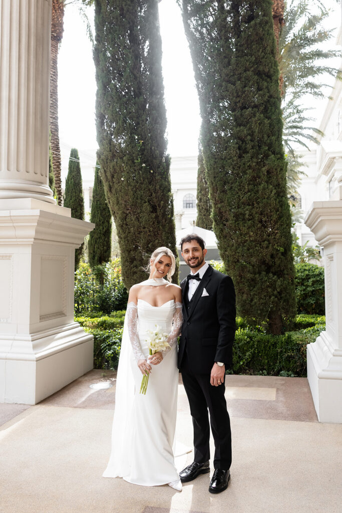 Bride and groom posing by the gardens at Caesars Palace in Las Vegas.